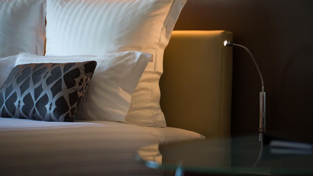 Close-up of bed & nightstand in a Room at Pullman Olympic park 