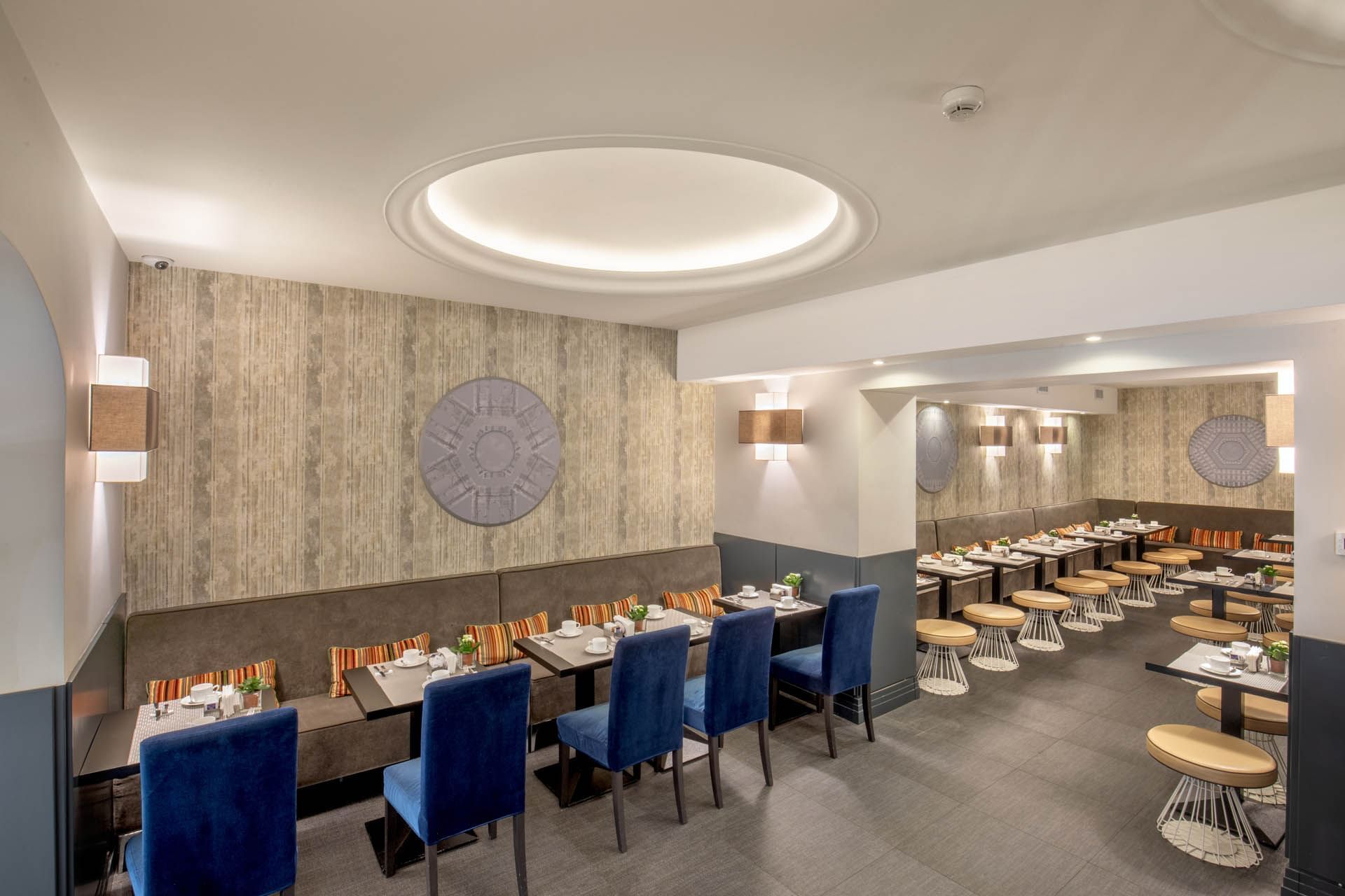 Interior of a modern restaurant featuring blue chairs, wooden tables, and stylish decor at The Republic Hotel
