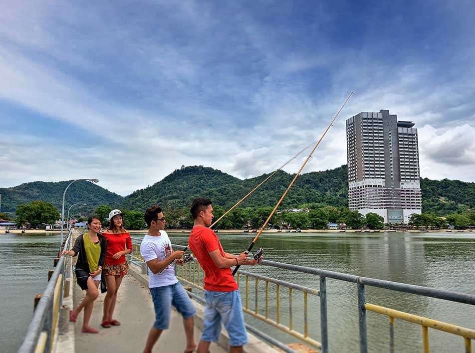 friends casting their fishing lines together during their holiday