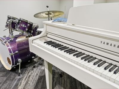 Yamaha piano and drum set in a room at Mayoral Drive Student Accommodation.