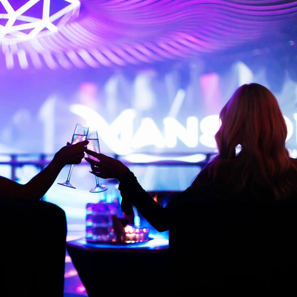 two women making a toast at Mansion Nightclub