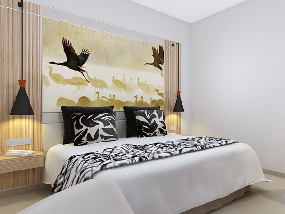 Superior Room with a bird art headboard, patterned pillows, and wall-mounted lamps used at Azalai Hotel Ouagadougou