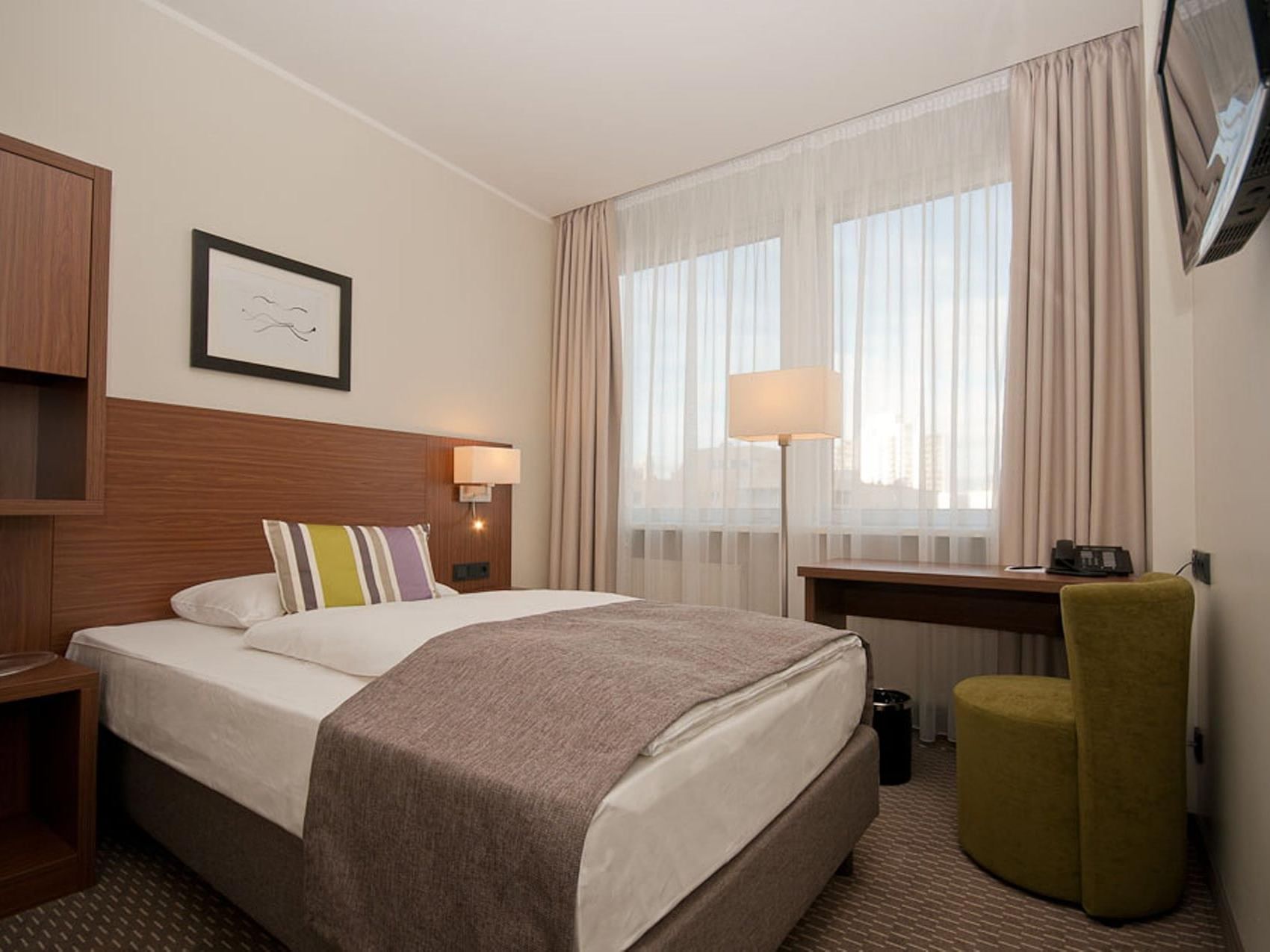 Standard room at Hotel Sylter Hof Berlin featuring a comfortable queen-sized bed and city views.