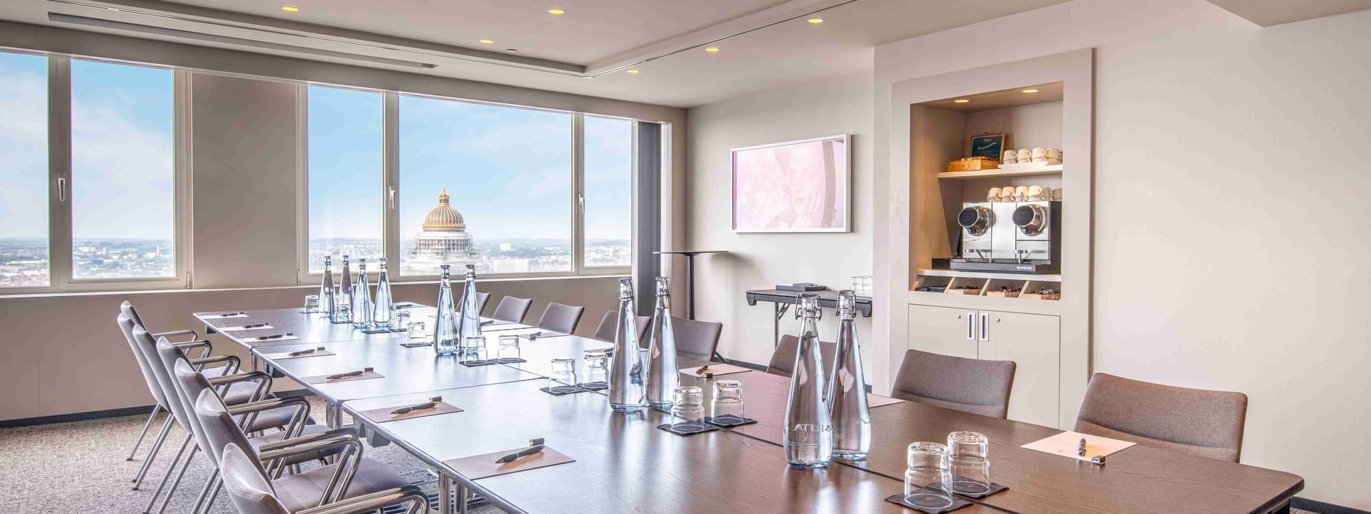 Meet 25 One Meeting room with a long table, chairs, and a view of a cityscape at The Hotel Brussels