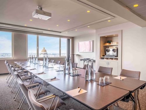 Meet 25 One Meeting room with a long table, chairs, and a view of a cityscape at The Hotel Brussels