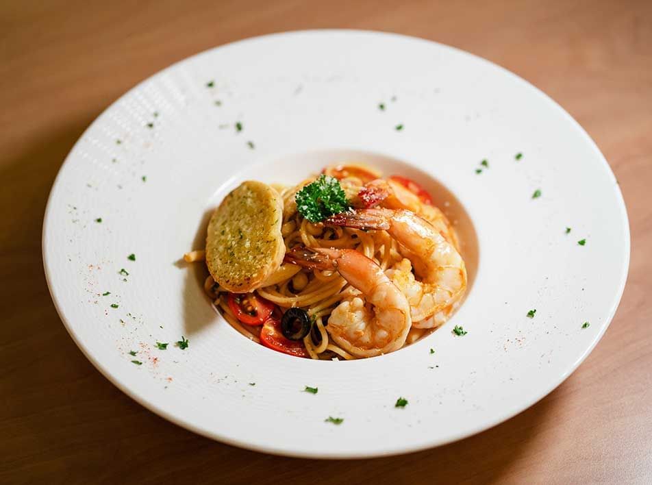 plate of pasta with prawn and basil, served at a half-board hotel restaurant