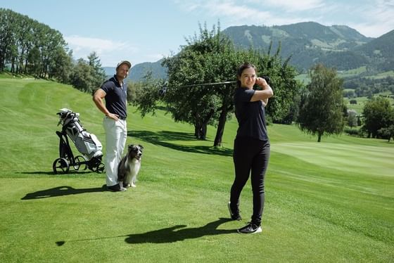 Paar mit Hund am 18 Loch Golfplatz von Schloss Pichlarn