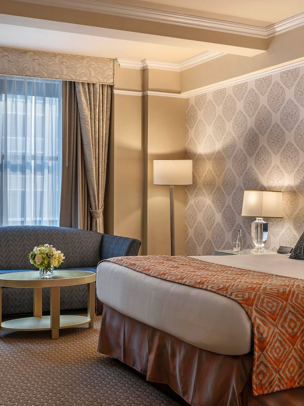 Bed with sofa near the window in the Junior Suite at Warwick New York