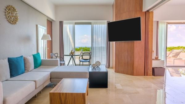 Spacious living area with Sofa with table and a TV in Aqua Suit at Live Aqua Beach Resort Cancun