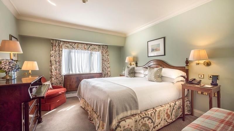 Cozy seating area and nightstands by the bed in Classic King at Warwick Hotels and Resorts