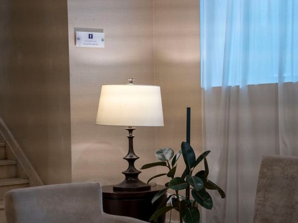 Lit lamp on table with plant in the lounge area at Saja by Warwick Makkah.