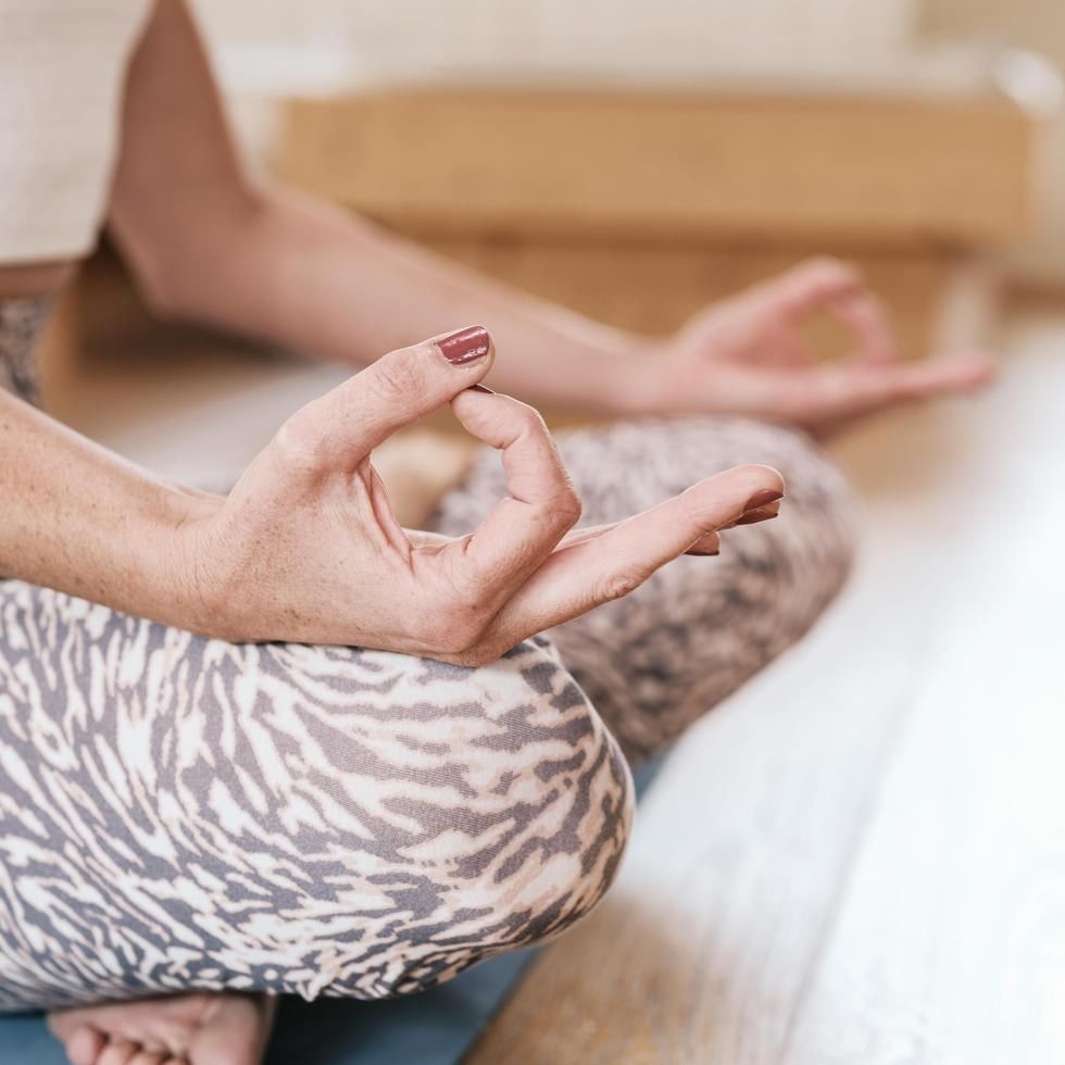 Donna in posizione yoga con mani unite in un gesto di preghiera e occhi chiusi.