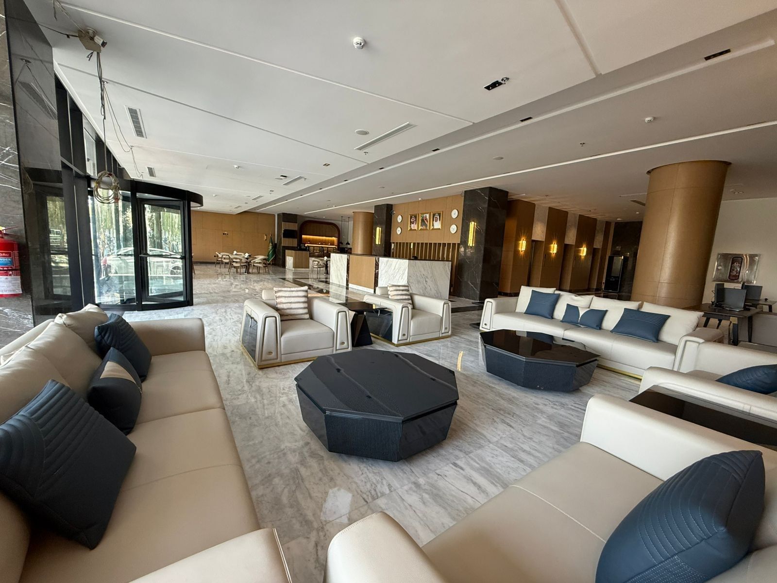 Cream sofas by geometric coffee tables under a white ceiling in the lounge at Warwick Jeddah Hotel & Spa