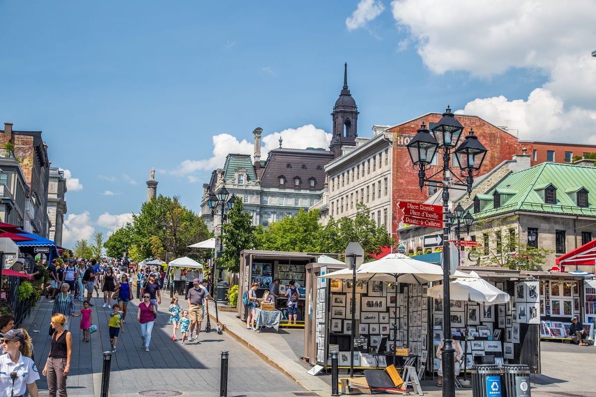 Rue animée avec des piétons et des vendeurs d'art en plein air à Warwick Le Crystal Montréal