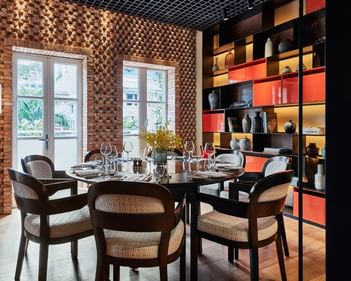 Cozy dining space with stylish chairs, wood accents, and colorful shelving in Square One at Park Hyatt Saigon