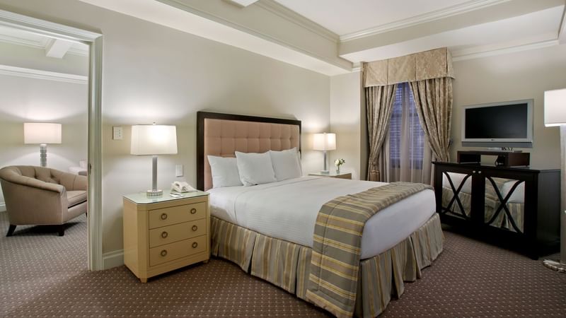 Comfy bed with side tables and TV in Premier Suite at Warwick New York