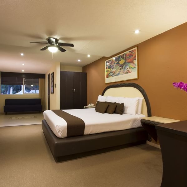 King comfy bed & a sofa in Deluxe Room at Gamma Hotels