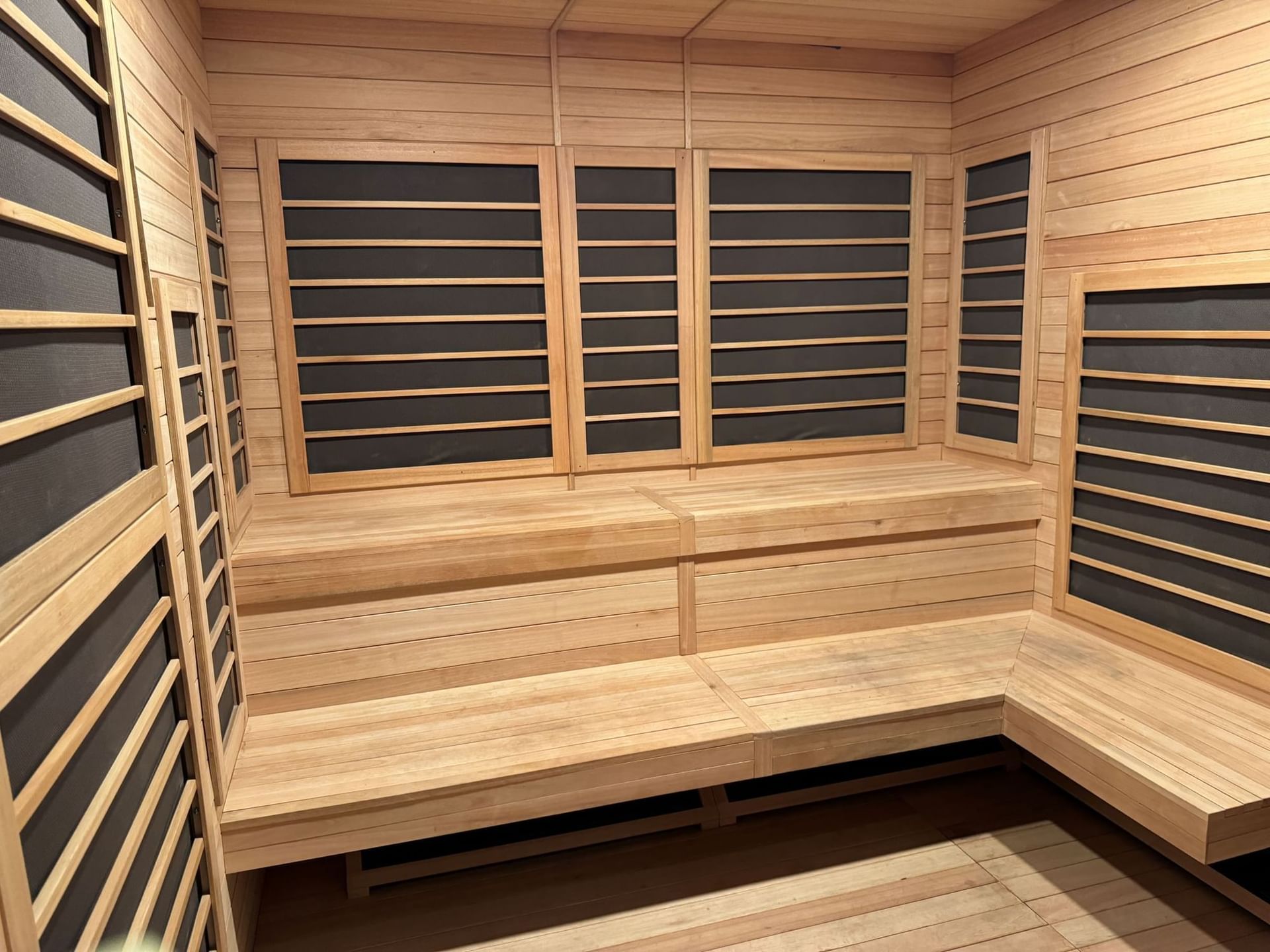 Empty, modern wooden sauna interior with multi-tiered benches at Shangri-La Monkey Island