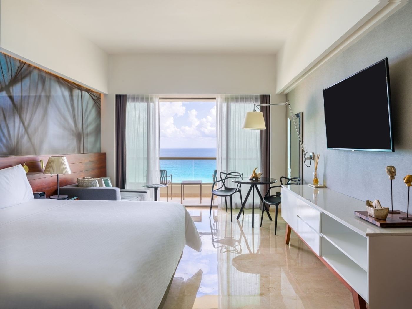 Comfy king bed and sitting area with TV in Premium Aqua Club Ocean Front at Live Aqua Beach Resort