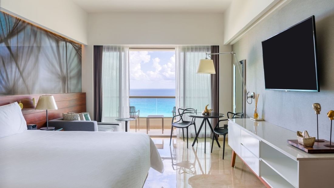 Comfy king bed and sitting area with TV in Premium Aqua Club Ocean Front at Live Aqua Beach Resort