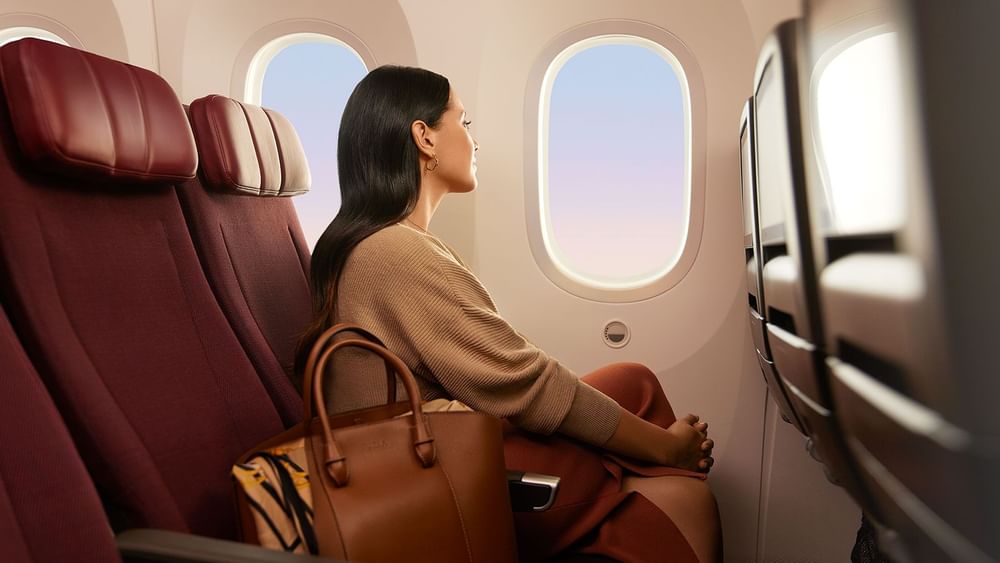 Lady sitting in an airplane seat, gazing out the window near Novotel Sydney Olympic Park