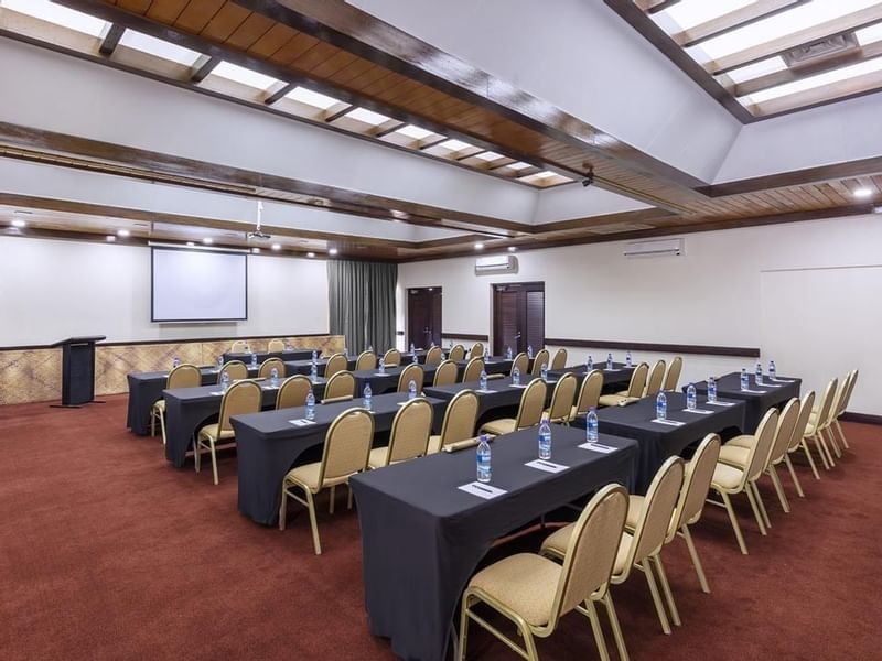 Pacific Ballroom meeting room with rows of black tables and gold chairs facing screen at warwick le lagon-vanuatu