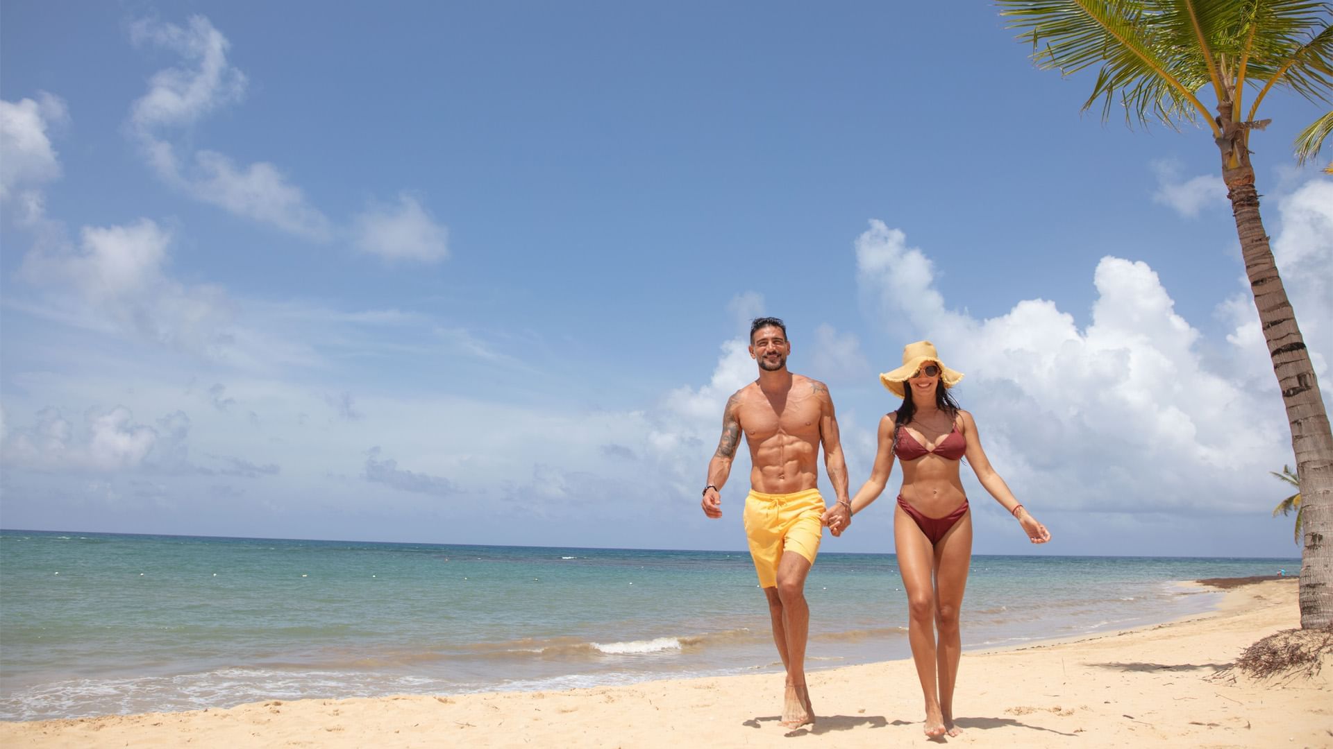 Couple holding hands & walking on the beach near Live Aqua Resorts and Residence Club