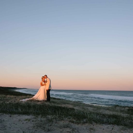 Wedding couple posing by the sea near Pullman Magenta Shores