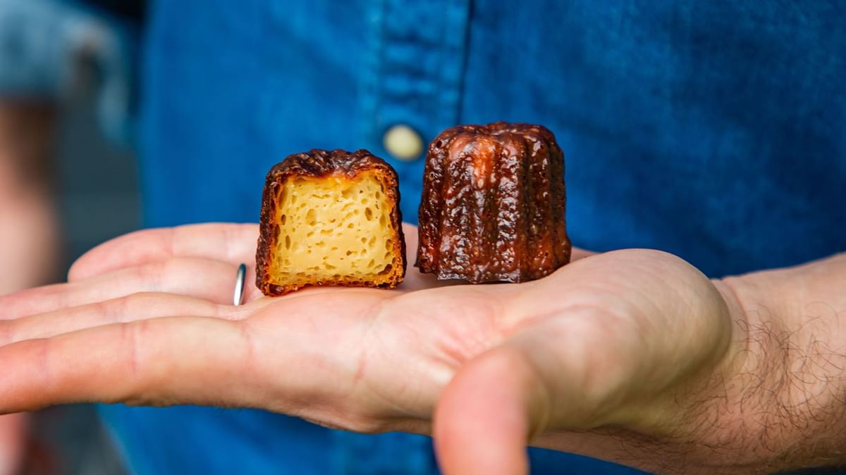 A person holding two caramelized pastries in Sacrebleu at Crown Hotels