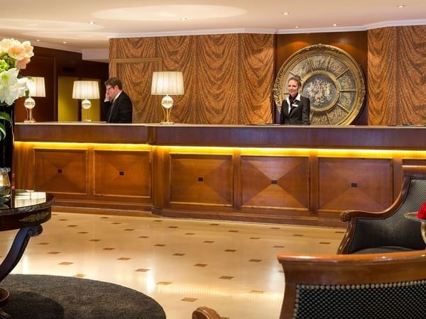 Receptie met twee medewerkers en luxe meubels bij Warwick Grand-Place Brussels.