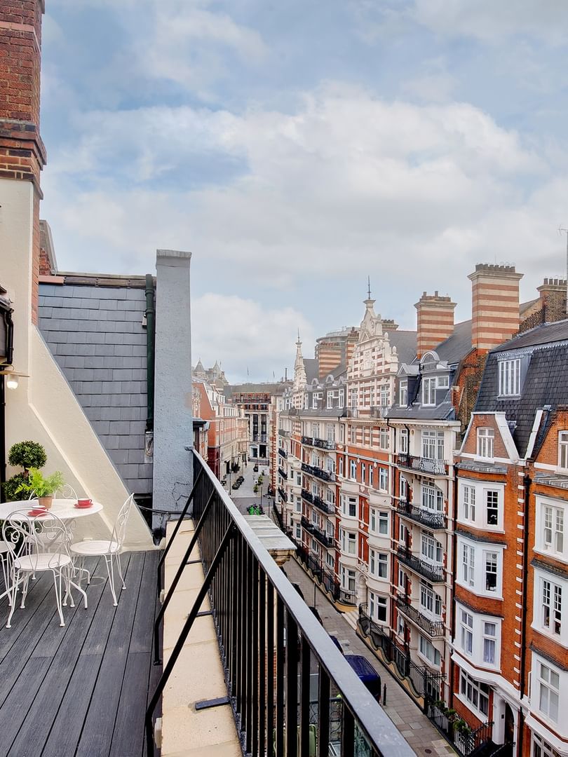 Penthouse balcony with city view and outdoor seating at The Capital Hotel, Apartments & Townhouse