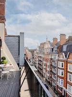 Penthouse balcony with city view and outdoor seating at The Capital Hotel, Apartments & Townhouse