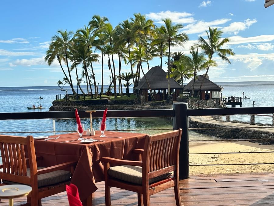 Beachside dining with wooden table and chairs at Warwick Fiji Resort and Spa.