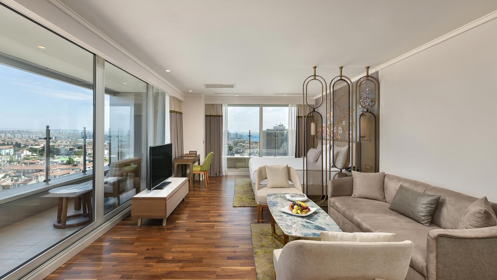 Junior Sea View Suite, living room with sofa, TV and city view at Titanic Port Bakirkoy