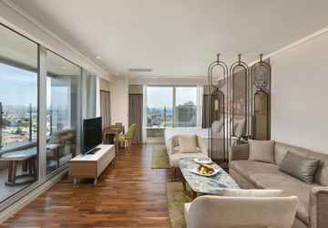 Junior Sea View Suite, living room with sofa, TV and city view at Titanic Port Bakirkoy