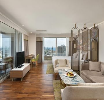 Junior Sea View Suite, living room with sofa, TV and city view at Titanic Port Bakirkoy
