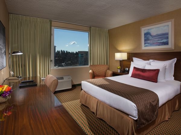Bed and desk in hotel room with window