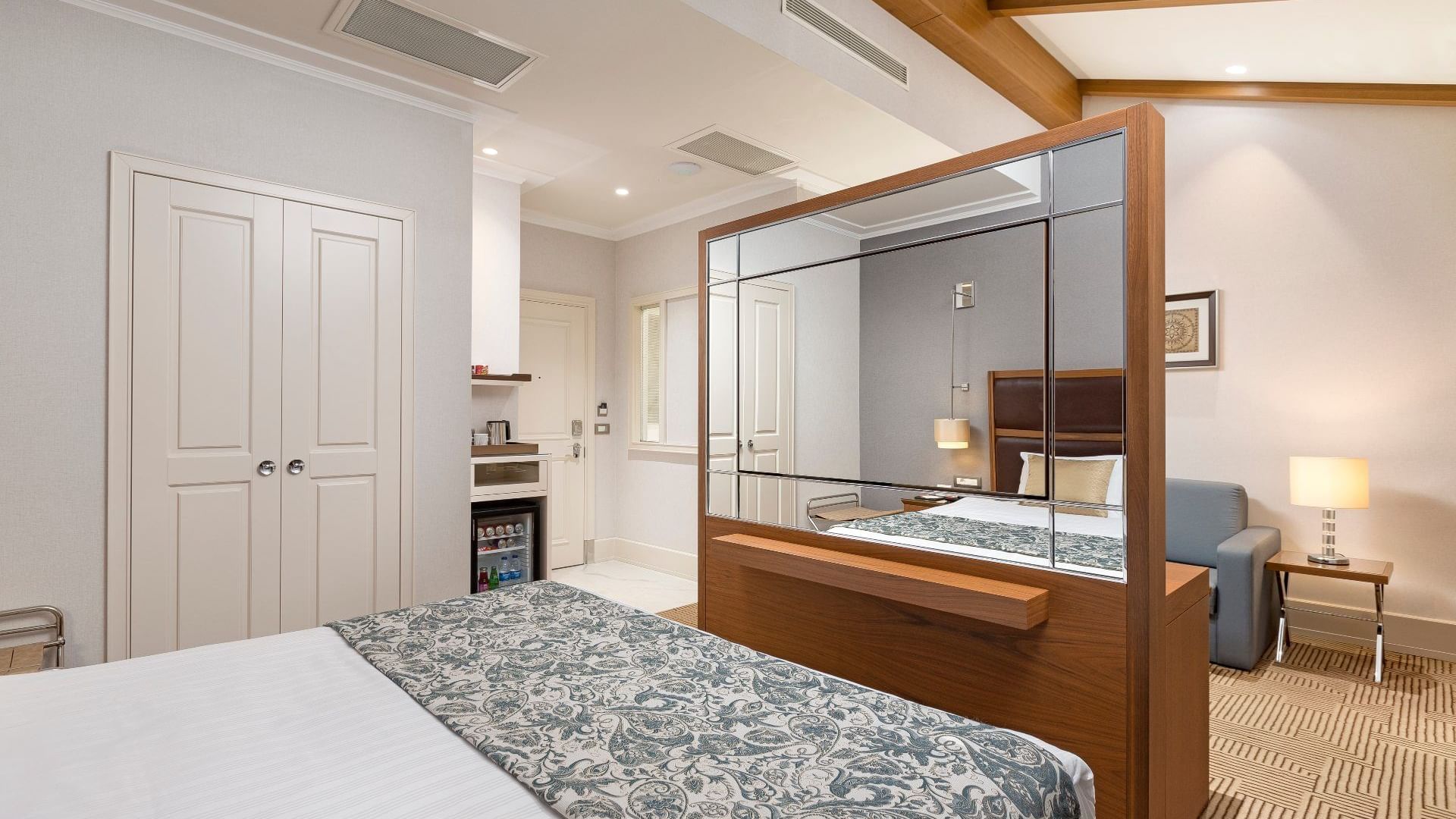 Comfy bed and mirror with a tea corner in the Executive Room at Titanic City Taksim