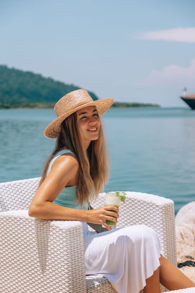 Lady wearing a hat and having a mocktail drink at Amaka Ocean Living Lodge