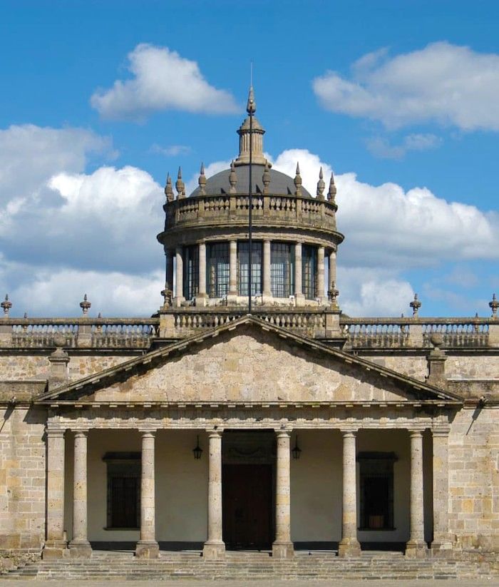 Stone pillars by a grand entrance under a tall dome with windows at Camino Real Pedregal Mexico