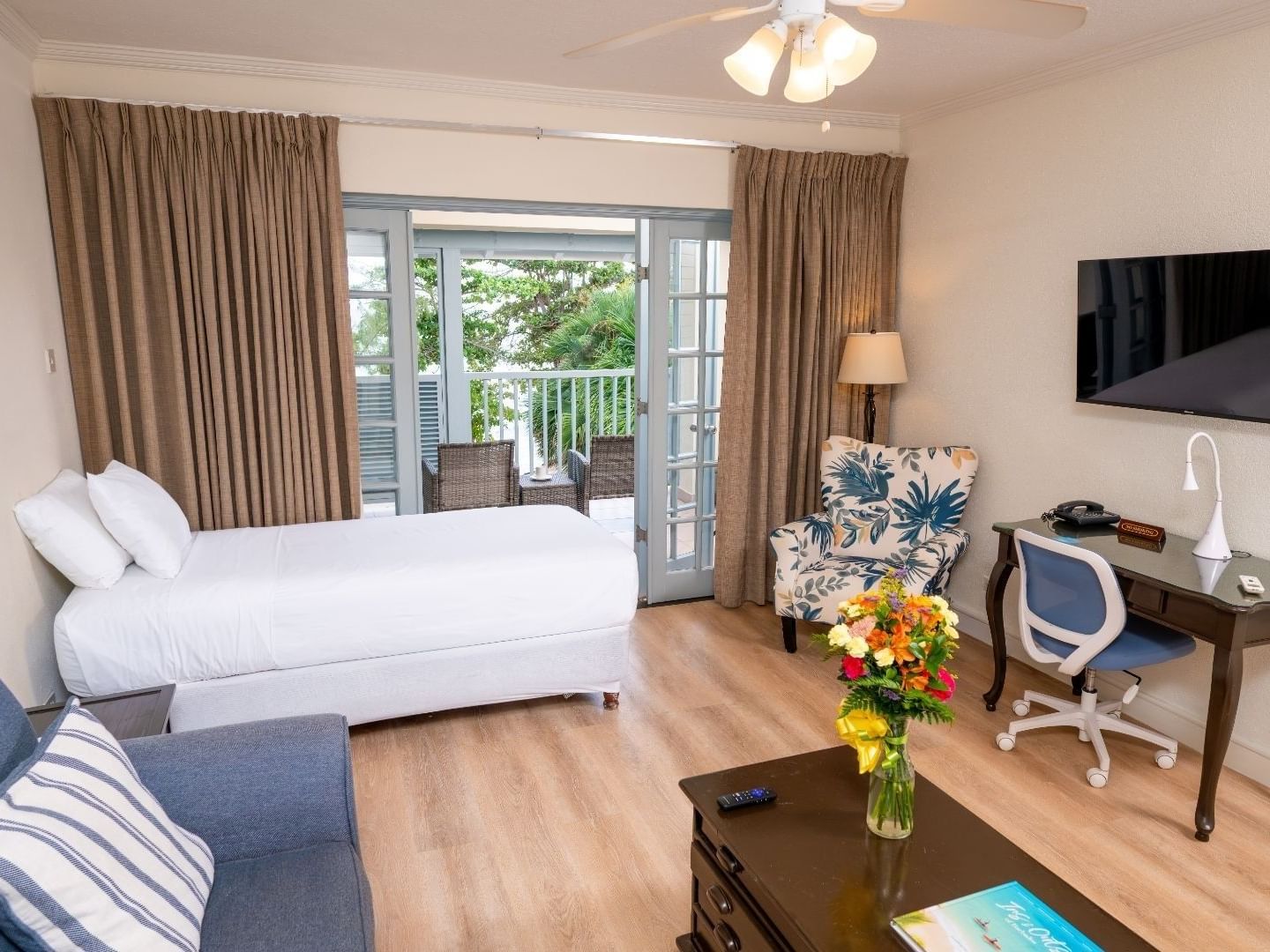 Cozy room with a bed, sofa, desk, and balcony at Savannah Beach Hotel.