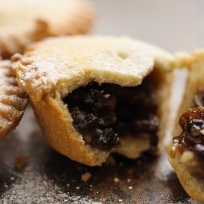 mince pie broken in half with mincemeat filling seeping out