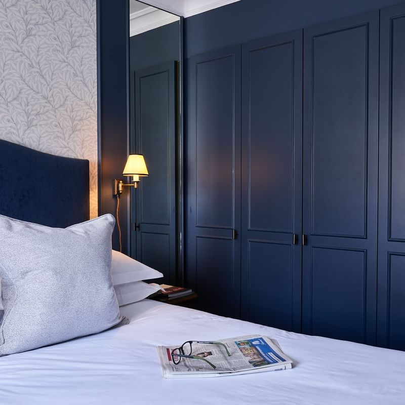 Newspaper & glasses arranged on the bed in Classic Bedroom at The Capital Townhouse