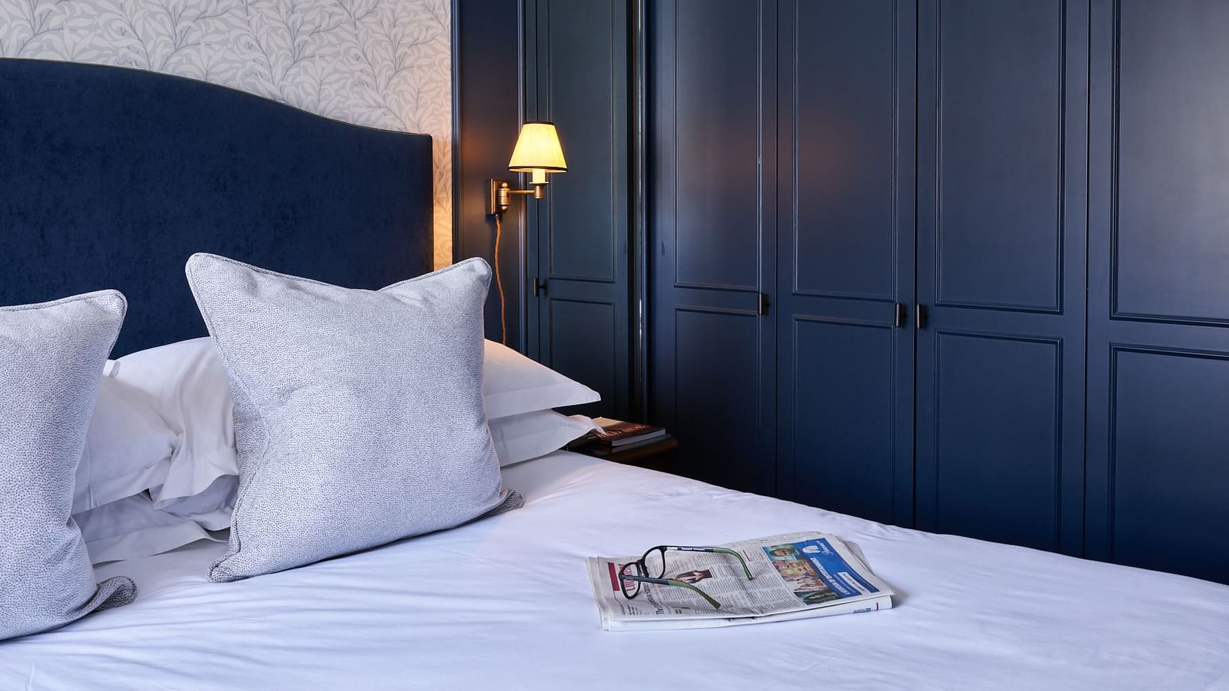 Newspaper & glasses arranged on the bed in Classic Bedroom at The Capital Townhouse