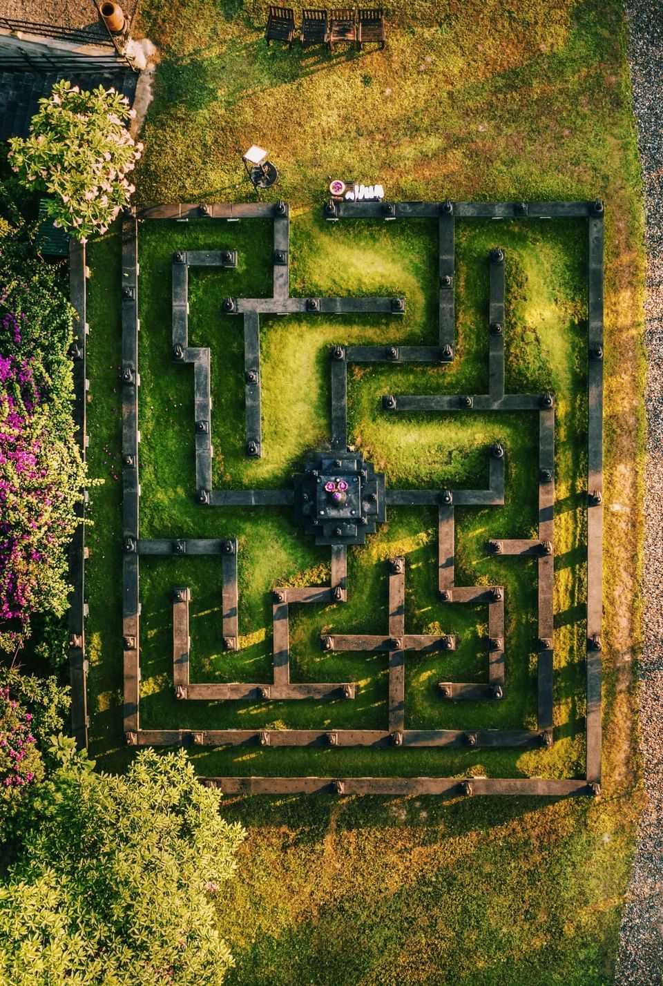 Aerial view of a meditation maze with a central stone surrounded by lush plants at The Dwarika's Himalayan Wellbeing