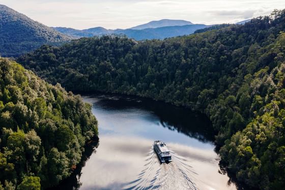 Gordon River Cruises navigating through calm water near Strahan Village