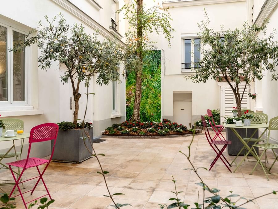 Inside garden with chairs and tables at Hotel Lecourbe