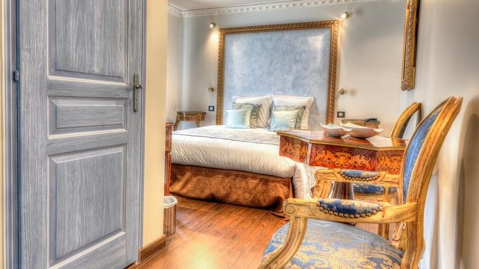 Chambre élégante avec grand lit, bureau et chaises décorées à l'Hôtel Villa Aultia.