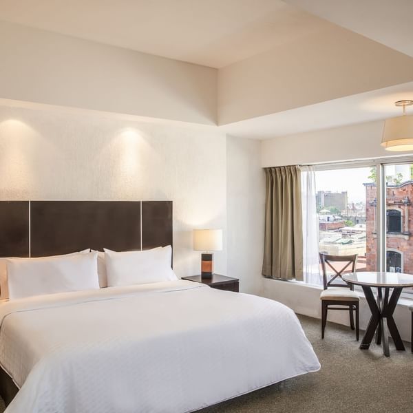 Bed & mini table in the Superior King Room at Gamma Hotels