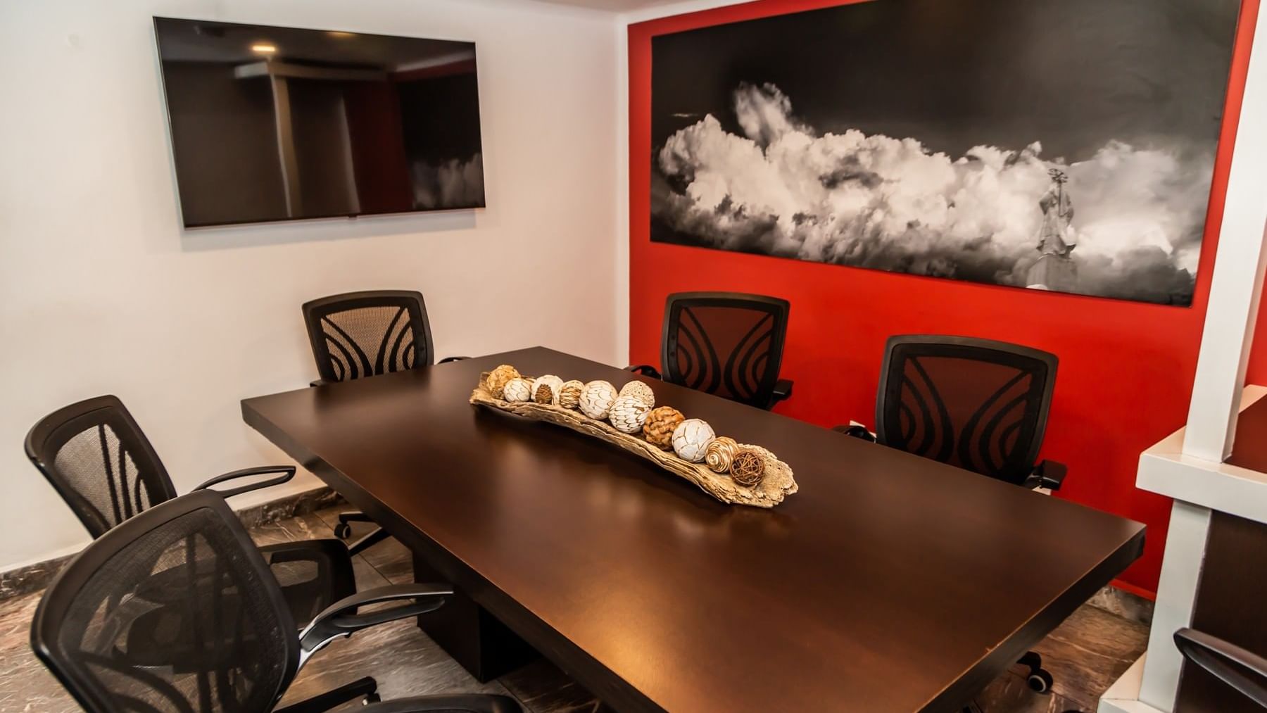 Boardroom set up with office table, wall art & TV in Sala de Juntas at Gamma Hotels